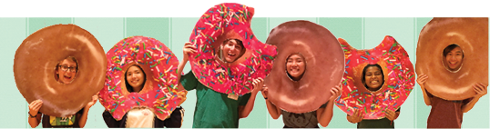 photo of 6 students posing with large donut signs